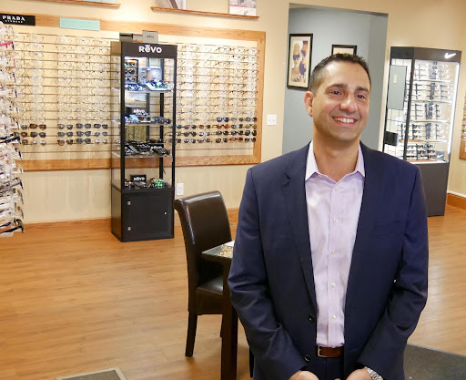 Dr. Scott Colonna standing inside the optical practice while smiling.
